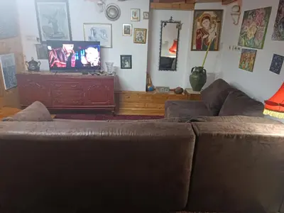 a living room with a brown couch and a tv at Maravilja 23 in Filmski Grad