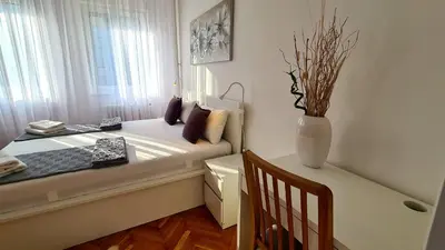 a small bed in a room with a vase at All In One Studio in Belgrade