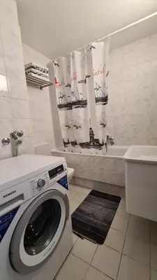 a bathroom with a washing machine and a bath tub at All In One Studio in Belgrade