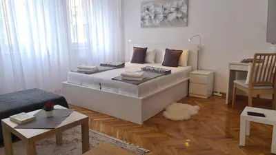 a bedroom with a large white bed in a room at All In One Studio in Belgrade