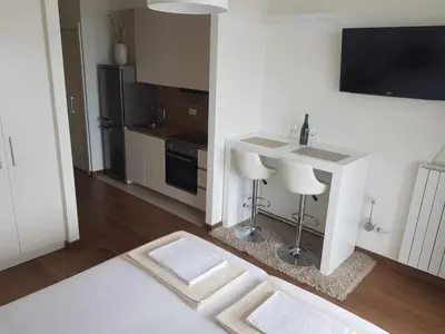 a kitchen with a sink and a table with a counter at All in One Belgrade Waterfront in Sajmište
