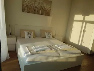 a bedroom with a bed with white sheets and pillows at All in One Belgrade Waterfront in Sajmište