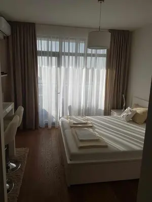 a bedroom with a large white bed with a window at All in One Belgrade Waterfront in Sajmište