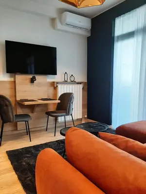 a living room with a tv and a couch and chairs at Belgrade Waterfront Lux Studio Apartment in Belgrade