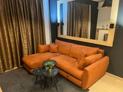 a brown leather couch in a living room with a mirror at Belgrade Waterfront Lux Studio Apartment in Belgrade