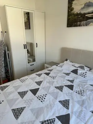 a bedroom with a black and white quilt on a bed at Apartman Uno Lux in Novi Grad