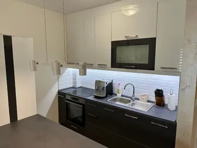a small kitchen with a sink and a tv at Apartman Uno Lux in Novi Grad