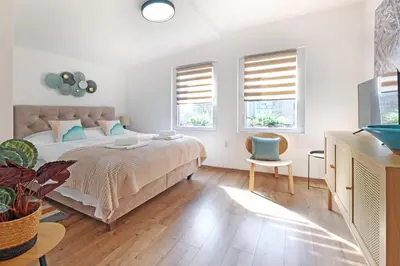 a white bedroom with a bed and two windows at Theater Apartment in Vračar (historical)