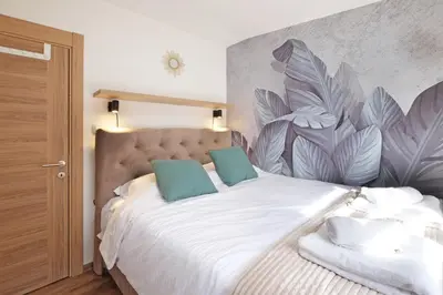 a bedroom with a large white bed with blue pillows at Theater Apartment in Vračar (historical)