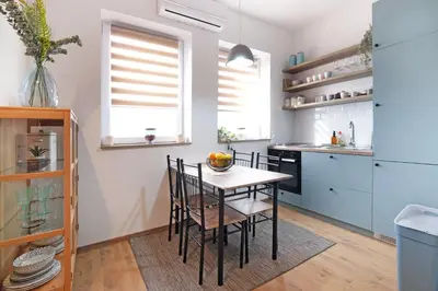 a kitchen with a table and chairs in a room at Theater Apartment in Vračar (historical)