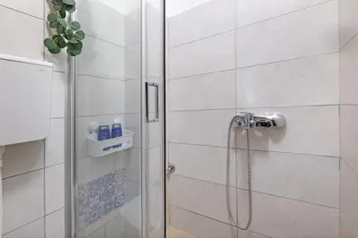 a shower with a glass door in a bathroom at Theater Apartment in Vračar (historical)