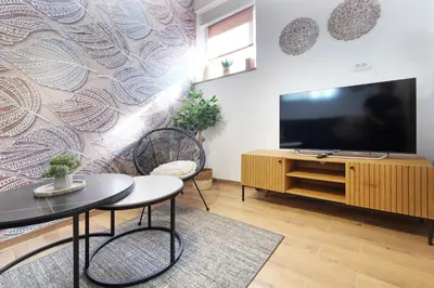 a living room with a flat screen tv and a table at Theater Apartment in Vračar (historical)