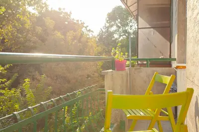 a yellow chair sitting on a balcony with a view at Apartment Lea in Belgrade