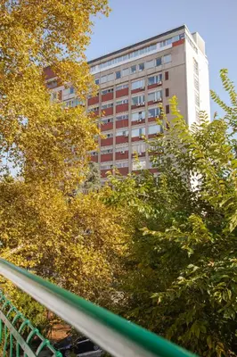 a tall building in the distance with trees in the foreground at Apartment Lea in Belgrade