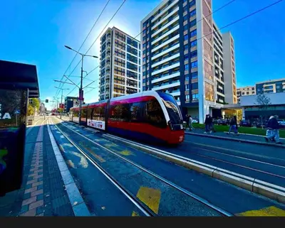 a red train on the tracks in a city at IVA HOME Apartment in Belgrade