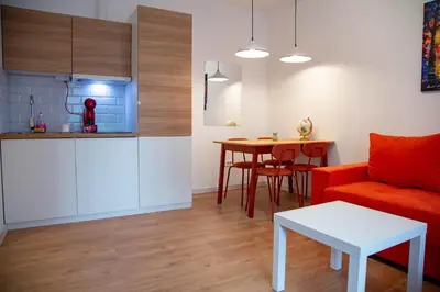 a living room with a red couch and a table at AV Smart Apartment in Pančevo