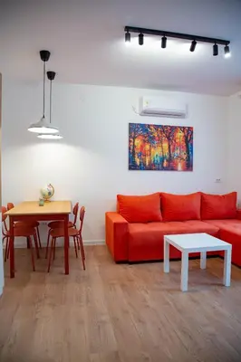 a living room with a red couch and a table at AV Smart Apartment in Pančevo