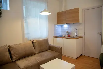 a living room with a couch and a kitchen at AV Smart Apartment in Pančevo