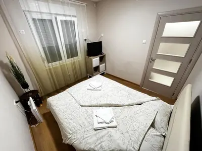 a small room with a bed and a window at Apartman Natali in Karaburma