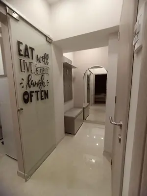 a hallway with an open door with a sign on the wall at Apartman Natali in Karaburma