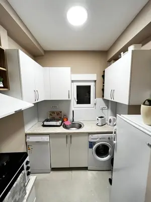 a small kitchen with white cabinets and a sink at Apartman Natali in Karaburma