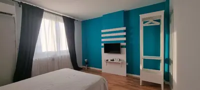 a room with a bed and a blue wall at Art d'aimer in Sajmište