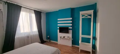 a bedroom with blue walls and a bed and a television at Art d'aimer in Sajmište
