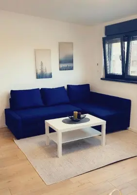 a blue couch with a white coffee table in a living room at Daki apartment in Belgrade