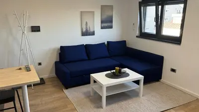a living room with a blue couch and a table at Daki apartment in Belgrade