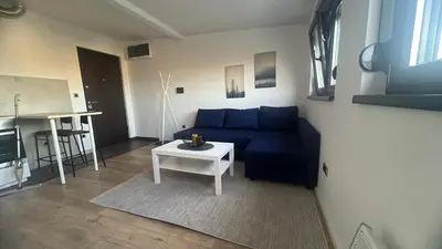 a living room with a blue couch and a table at Daki apartment in Belgrade