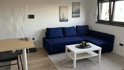a living room with a blue couch and a table at Daki apartment in Belgrade