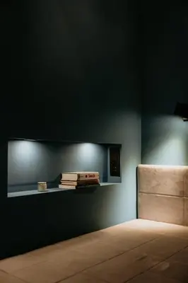 a room with a wall with a shelf and a chair at Sweet Home in Belgrade