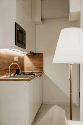 a kitchen with a sink and a microwave and a lamp at Sweet Home in Belgrade