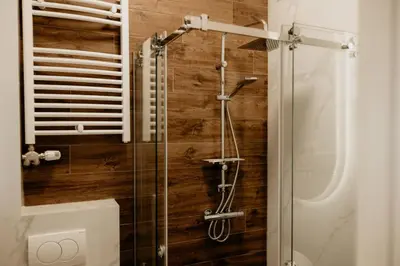 a glass shower in a bathroom with wooden walls at Sweet Home in Belgrade