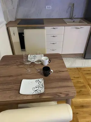 a wooden table with wine glasses and a laptop on it at Apartman Comfort Beograd in Belgrade