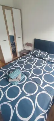a bedroom with a bed with a blue and white carpet at Apartman Comfort Beograd in Belgrade