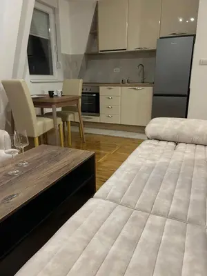 a kitchen with a table and a large bed at Apartman Comfort Beograd in Belgrade