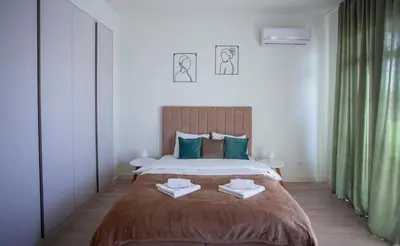a bedroom with a large bed with two towels on it at inJoy in Sajmište