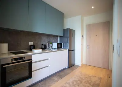 a kitchen with white cabinets and a stove top oven at inJoy in Sajmište