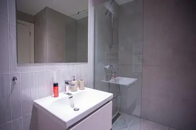 a white bathroom with a sink and a shower at inJoy in Sajmište