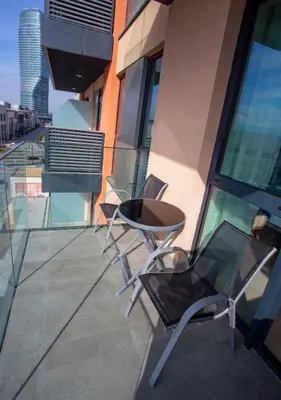 two chairs and a table on the balcony of a building at inJoy in Sajmište