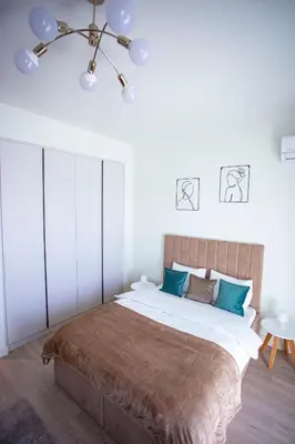 a bedroom with a large bed with green pillows at inJoy in Sajmište