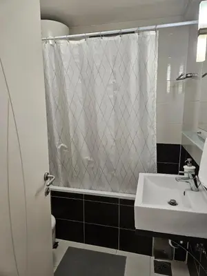 a bathroom with a shower curtain and a sink at Sweet Pleasure in Belgrade