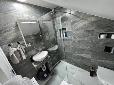 a bathroom with a sink and a glass shower at Airport vicinity Apartment Star 1 in Belgrade