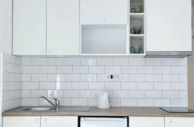 a kitchen with white cabinets and a sink at Apartman Tašmajdan in Belgrade