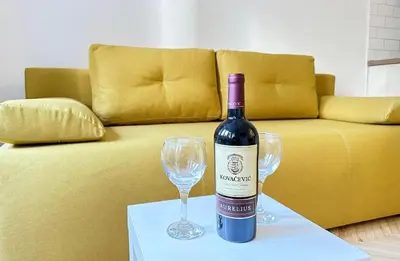 a bottle of wine and two wine glasses on a table at Apartman Tašmajdan in Belgrade
