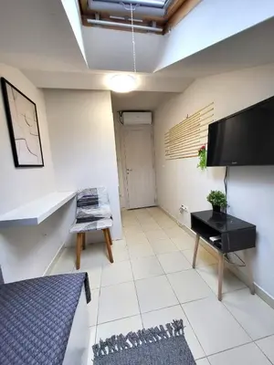 a living room with a flat screen tv and a table at Guesthouse Ožegović in Belgrade