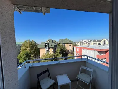 two chairs on a balcony with a view of a city at Una_2 in Čukarica