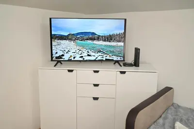 a flat screen tv on top of a white dresser at Sunset Apartment in Smederevo