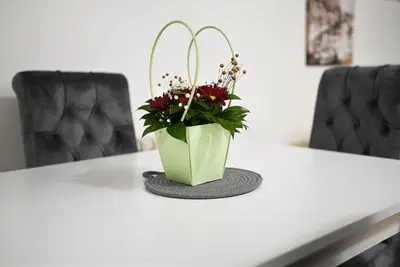 a green vase with flowers sitting on a table at Sunset Apartment in Smederevo